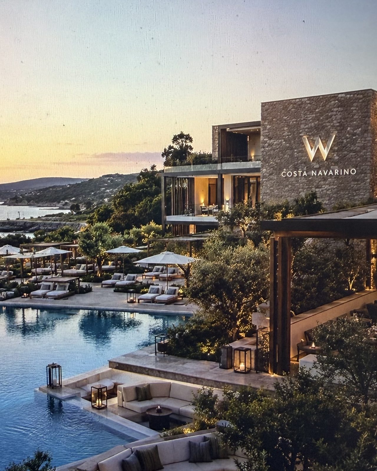 The W Hotel at Costa Navarino at dusk, its terraced pools stepping down toward the sea