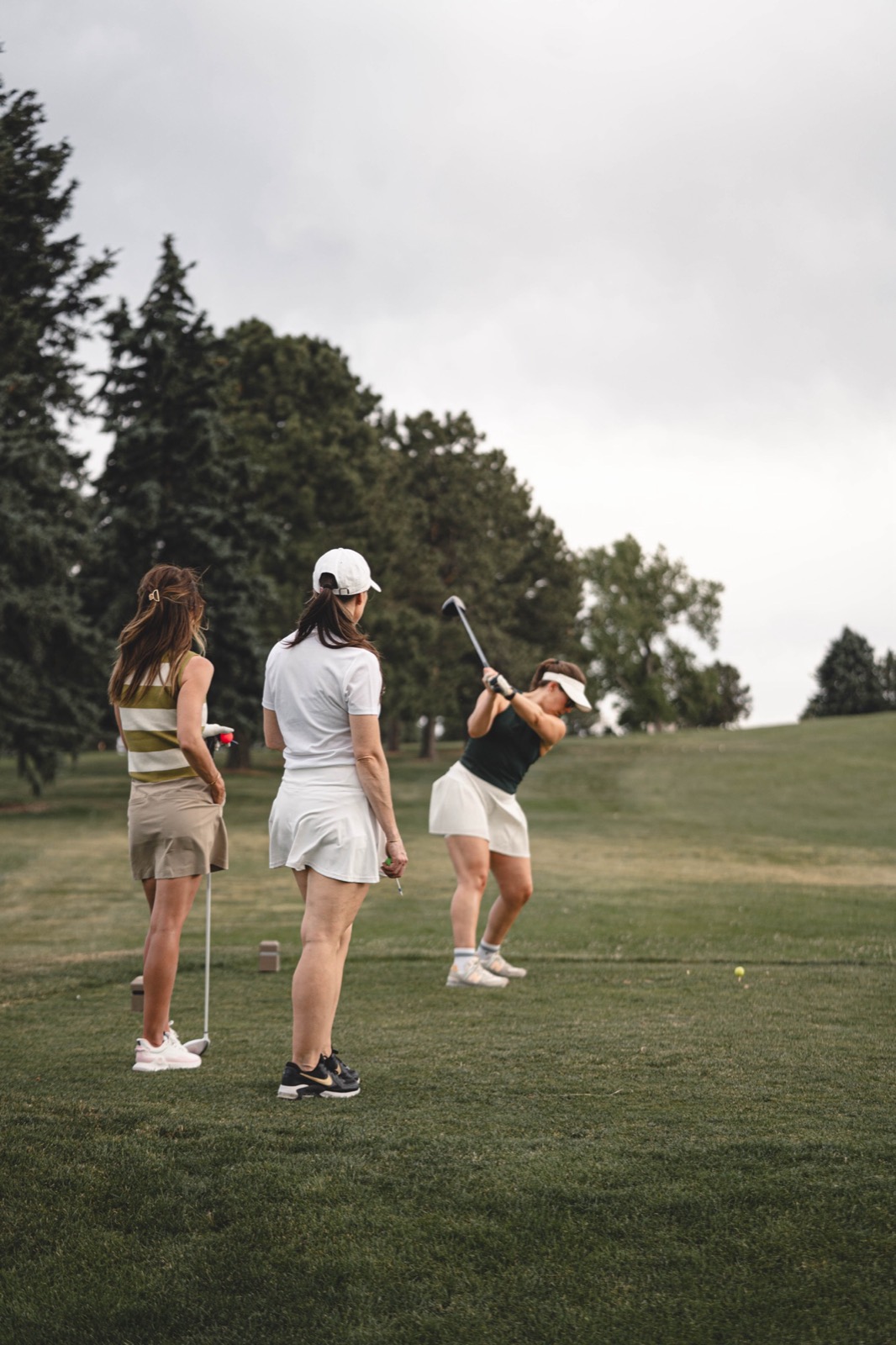 A group of women on the tee box, one mid-swing